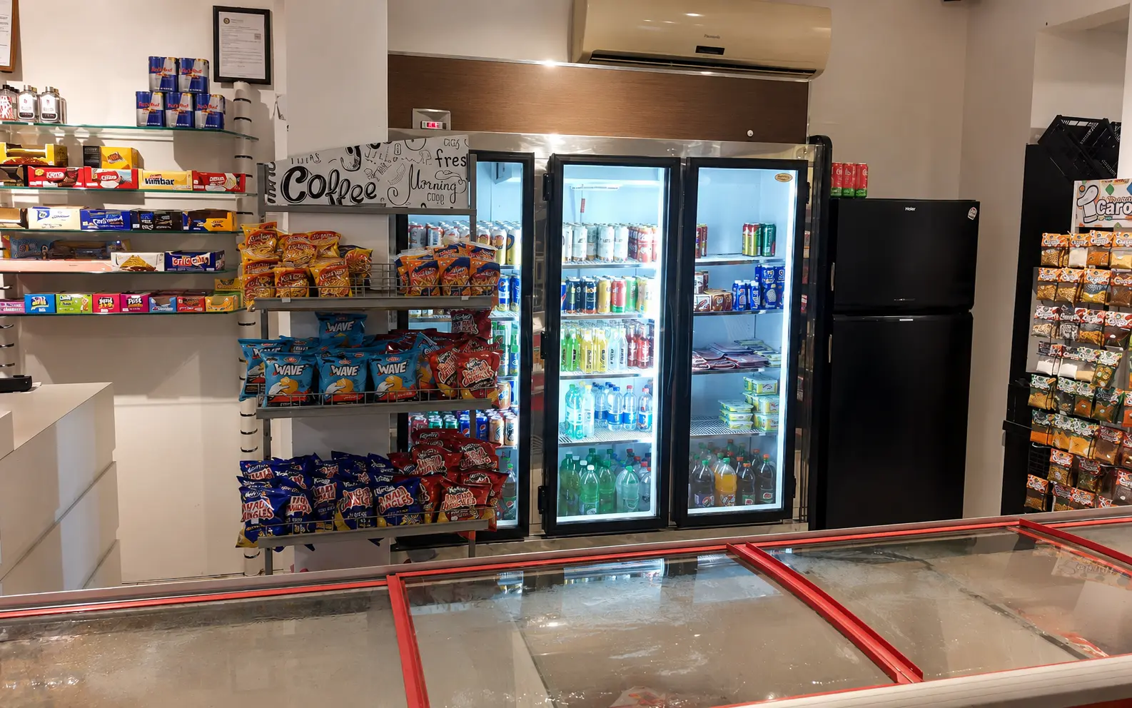 Bebidas e produtos organizados no interior da primeira loja da Baixada